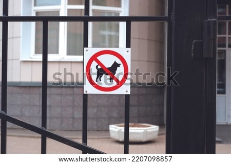 No dogs allowed. Prohibition sign hanging on a gate at the entrance to a building. 