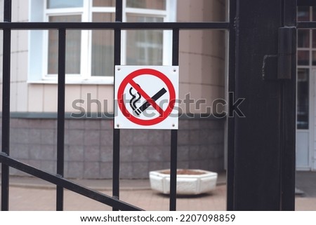No smoking sign. Prohibition sign hanging on a gate at the entrance to a building. 
