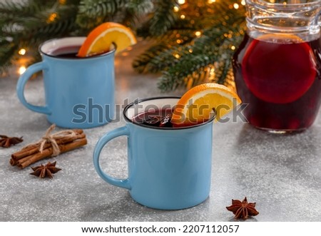 Two mugs of Gluhwein or mulled red wine with spices and orange slices. Winter time. Holiday concept.  Royalty-Free Stock Photo #2207112057