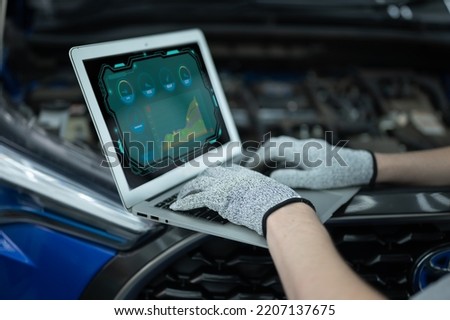 Mechanic Asian Arab man close up using laptop computer and diagnostic software to tuning fixing repairing car engine automobile vehicle parts using tools equipment in workshop garage support services Royalty-Free Stock Photo #2207137675