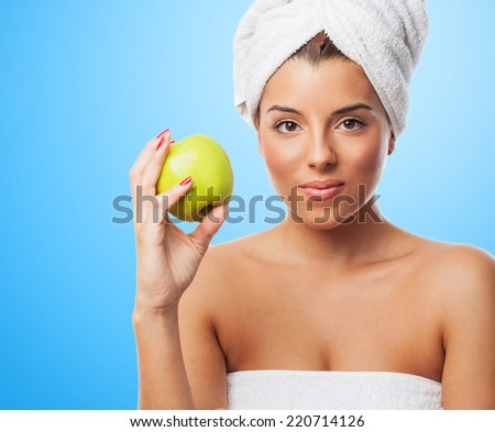 portrait of a young woman eating an apple after taking a bath