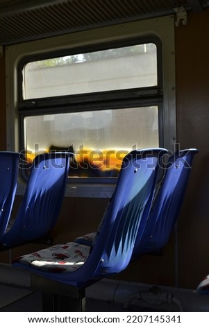 A plastic blue seat in a train car. A plastic blue seat in a train carriage, basked in the afternoon sun.