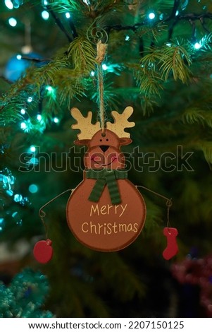 Close up of holiday electric blue garlands on fir branch with Christmas tree decoration and candy sweet. Candy cane hanging onto the branch of a Christmas tree