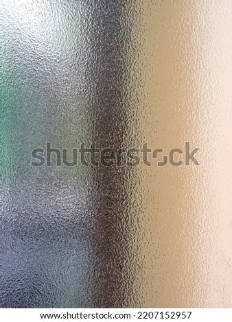 The rough surface of frosted glass with blurry window wooden frame backdrop. 