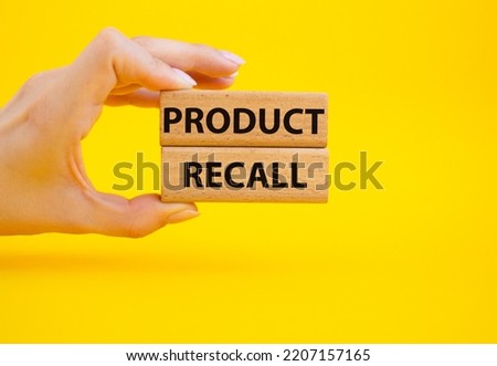 Product recall symbol. Concept words Product recall on wooden blocks. Beautiful yellow background. Businessman hand. Business and Product recall concept. Copy space.