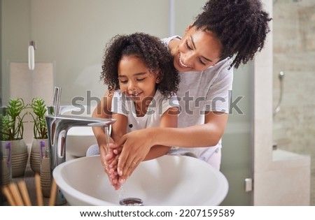 Family, washing hands and child with mom rinsing, cleaning and good hygiene against bacteria or germs for infection or virus protection in bathroom. Girl kid with woman for health and cleanliness Royalty-Free Stock Photo #2207159589