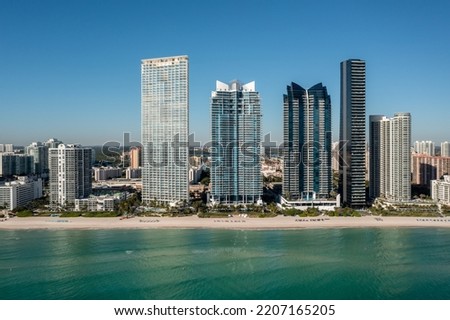 Drone view, miami beach with buildings in the background, beautiful blue sky and beach, waves, vacation