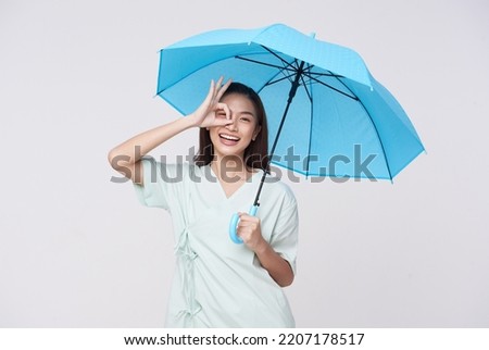 Happy Asian woman standing and holding blue umbrella isolated on white background,  life insurance and protection concept.