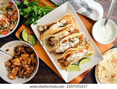 Chicken Tacos Topped with Pico de Gallo and Cilantro-Lime Sauce: Grilled chicken tacos surrounded with toppings and tortillas