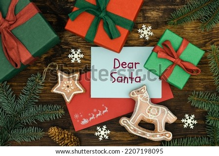 Baby letter to Santa Claus, red envelope with a postcard with handwritten words, Dear Santa, Christmas decorations, gifts, gingerbread cookies, Merry christmas