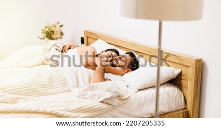 Beautiful smiling couple hugging in bed in the morning. Healthy relationship concept.