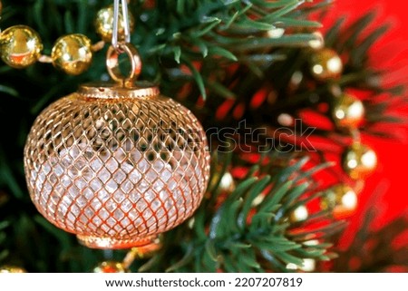 Beautiful shiny Christmas tree decoration close-up. Artificial Christmas tree with decorations on a red background