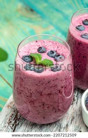 Bilberry yogurt cocktail on a blue background. Natural detox. vertical image. top view. place for text.