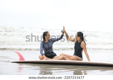 Beautiful surfer asian girl on the beach . Asian woman playing surf on sunlight.