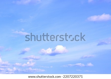 Clear, peaceful blue sky with fluffy white clouds floating slowly Background Banner Screensaver on the monitor.