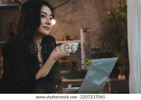 charming smart Asian business woman entrepreneur use laptop to work training company career development seminar sit table hold takeout mug hot beverage in loft office or cafe, freelance job lifestyle