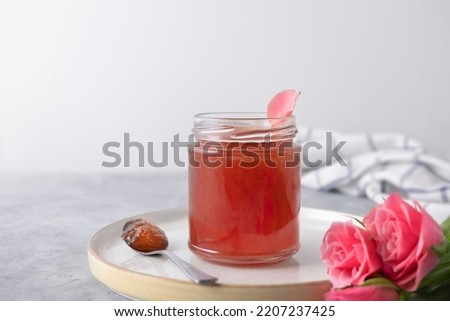 Rose petal jam in a glass jar on neutral grey kitchen table with copy space Royalty-Free Stock Photo #2207237425