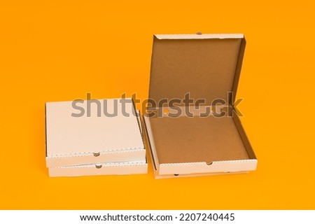 pizza box open on yellow background