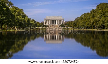 Panoramic view of the Lincoln Memorial in Washington DC in a nice sunny summer day with the water mirror reflecting the architecture of the landmark and its surroundings gardens.