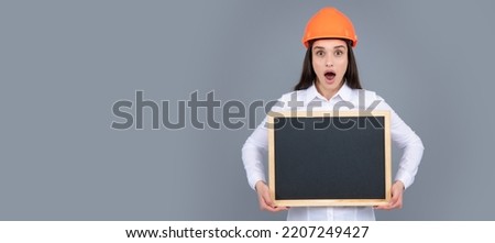 Surprised amazed wow woman construction manager. Woman builder isolated portrait with protect helmet and sign board. Woman isolated face portrait, banner with mock up copy space.