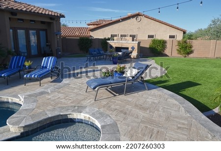 A desert landscaped backyard in Arizona featuring a travertine tiled pool deck. Royalty-Free Stock Photo #2207260303