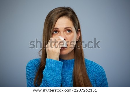 Woman blows his runny nose in napkin. Isolated female portrait healthcare and medical concept. Royalty-Free Stock Photo #2207262151