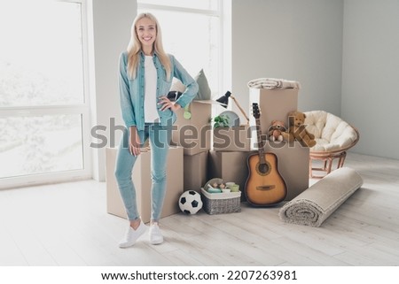 Photo of charming sweet young lady dressed denim shirt moving new home boxes stack indoors apartment