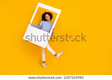 Full size portrait of cheerful pretty person hold paper album card empty space isolated on yellow color background