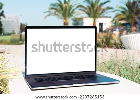 laptop mockup. Notebook with white screen with palm tree leafs on background. Vacation, traveling and remote work and study concept. Empty copy space, blank screen modern laptop