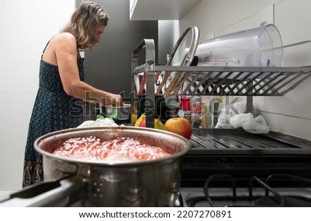Young woman preparing cheesecake in the kitchen with various ingredients. Family gastronomy. Salvador, Bahia, Brazil