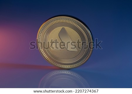 Avalanche AVAX Cryptocurrency Physical Coin Placed on reflective surface and lit with orange and blue lights. Royalty-Free Stock Photo #2207274367