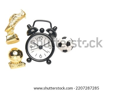 A flatlay picture of alarm clock, ball, golden ball and golden boot on copyspace white background. Time for football match