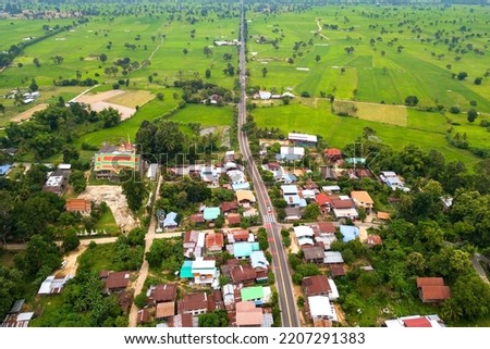 Top view Aerial photo from flying drone over Beautiful green rice field and village from above.The road passes through small villages and leads to green rice fields.