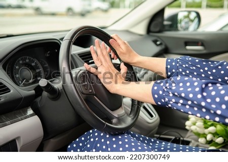 Woman driver hand honking her car horn to prevent accident. Driving safety concept Royalty-Free Stock Photo #2207300749