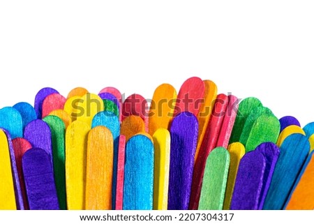 Colorful popsicle sticks are arranged alternately on a white background. Children use it to make art, to enhance skills and creativity. This image is perfect to use as a background for creative ideas.