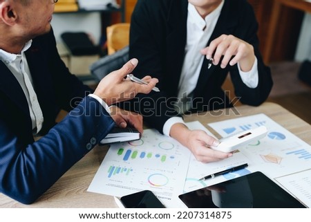 financial, Planning, Marketing and Accounting, Asian young Economist using calculator to calculate investment documents with partners on profit taking to compete with other companies. Royalty-Free Stock Photo #2207314875
