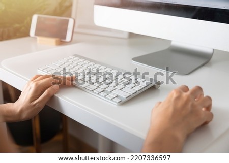 Close-up hand of Asian woman working office worker typing on keyboard at home office.