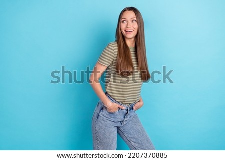 Portrait photo of young pretty gorgeous lady wear striped khaki t-shirt put hands pockets dreamy look empty space ad isolated on blue color background