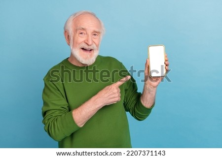 Portrait of positive funky aged person indicate finger empty space proposition isolated on blue color background