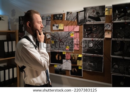 Policeman analyzing information of crime on investigation board, professional working in office at night. Copy space