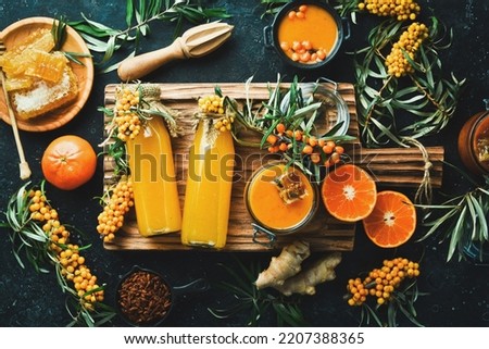 A bottle of homemade drink with honey, sea buckthorn and vitamin C. Autumn drinks. On a dark background. Top view. Royalty-Free Stock Photo #2207388365
