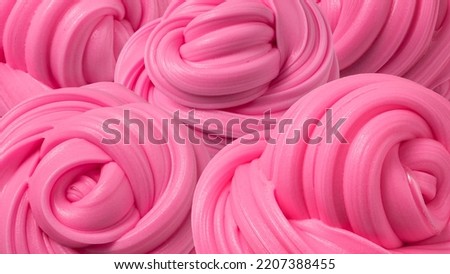 Swirl fluffy slime green background. Textured volumetric molded slime. backdrop of pink gum Royalty-Free Stock Photo #2207388455
