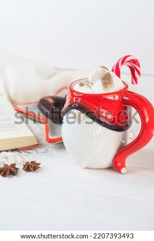 New Year's Eve background, Santa Claus mug with marshmallows, Christmas cookies, open book