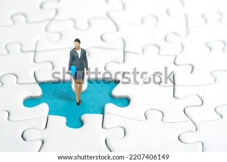 Miniature people toy figure photography. A businesswoman standing above missing piece of puzzle jigsaw. Image photo