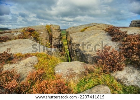 Burbage Edge is a gritstone escarpment overlooking the Burbage district of Buxton in Derbyshire, in the Peak District. The hill's summit is 500 metres above sea level.  Royalty-Free Stock Photo #2207411615