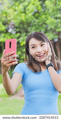 asian young woman take selfie happily with smart phone in the park or campus