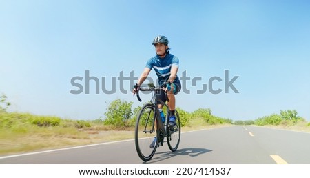 low angle of asian man ride a bicycle on countryside happily