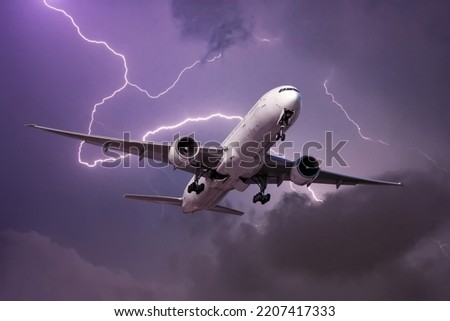 Landing airliner during a strong wind in a storm against the backdrop of a flash of lightning Royalty-Free Stock Photo #2207417333