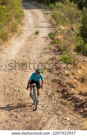 A male cyclist in a gravel road bicycle ride in the  mountains of Costa Blanca, Alicante, Spain