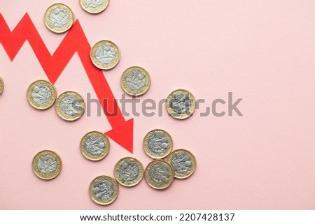 British coins with a red downward arrow. Uk economic crisis
